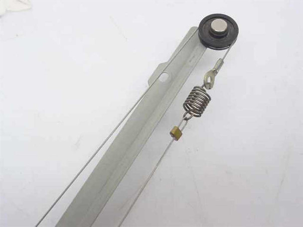 Close-up of linear carriage rail arm showing steel drive cable, tension spring, and end pulley detail