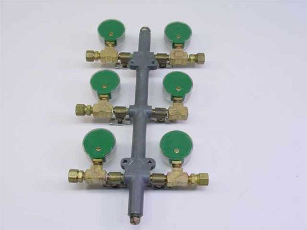 Rear view of 6-outlet gas manifold showing green gauge faces, brass compression fittings, and bilateral outlet configuration