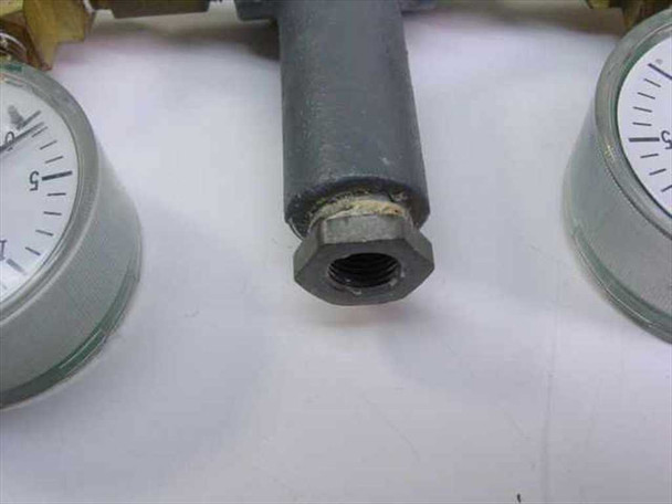 Close-up of 1/4 NPT inlet fitting at top of manifold body showing threaded female connection and painted steel housing