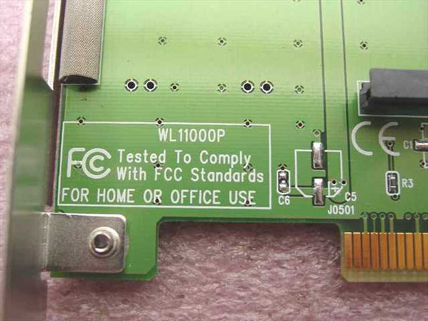 SMC WL11000P PCB close-up showing FCC 'Tested to Comply with FCC Standards for Home or Office Use' silkscreen and CE mark