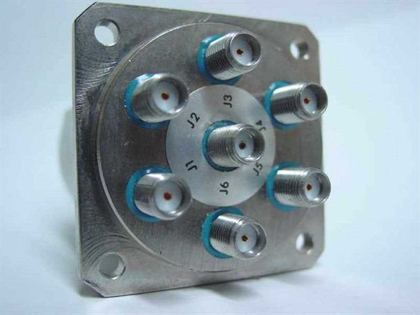 K&L Microwave 6MP-28-F-0-4 SP6T coaxial relay — bottom flange view showing six SMA female connectors labeled J1 through J6 arranged radially with blue seals on stainless mounting plate