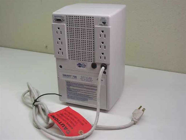 Tripp Lite SMART700 SM3413 UPS rear view showing 6 NEMA 5-15R outlets, ventilation grille, DB9 serial port, and power cord with caution tag