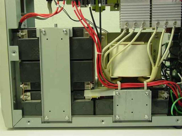 Minuteman PML2000 interior view showing empty battery bays, battery interconnect wiring (red and black cables), and internal transformer