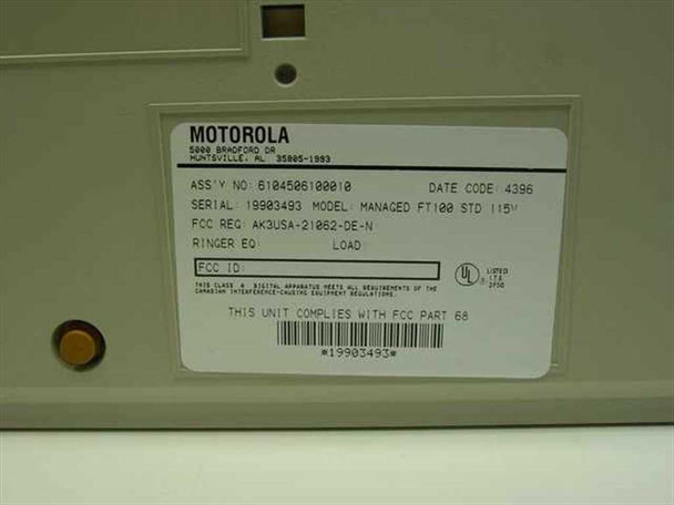 Motorola FT100M bottom label showing assembly number 6104506100010, serial number, model MANAGED FT100M STD 115V, date code 4396, and FCC Part 68 compliance