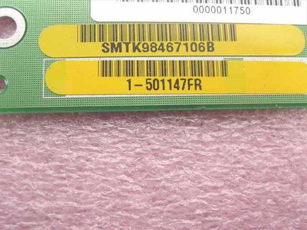 Close-up of yellow labels on GNP Computers control board showing SMTK98467106B and 1-501147FR part number barcodes