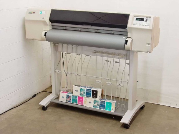 HP DesignJet 2500CP C4704A wide format color plotter on rolling stand, front view with ink cartridge boxes on lower shelf