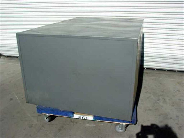 Rear view of gray steel industrial storage cabinet showing plain steel back panel, mounted on a blue pallet with casters