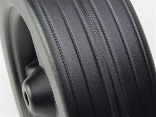 Close-up of ribbed tread surface on Specialty Mfg. Co. 9-inch plastic wheel showing tread detail and spoke hub edge