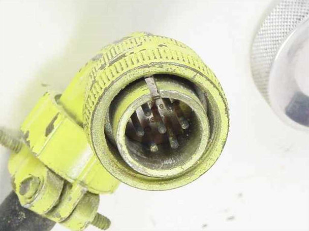 Close-up of yellow multi-pin military-style circular connector on cable end showing pin contacts and wear to connector housing