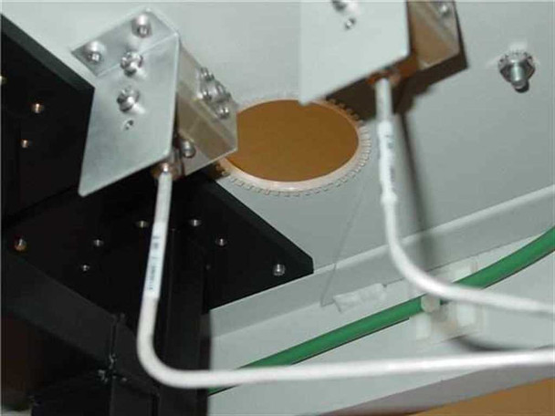 Varian rackmount cabinet interior bottom section showing circular wafer or disk component on waveguide bracket with SMA-style connectors and cabling