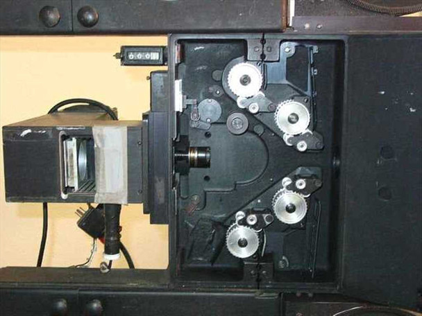 Elicon Ultradrive 600 film transport mechanism — open side access panel revealing toothed sprocket gears, drive pulleys, and film gate assembly; projection/light source module visible at left