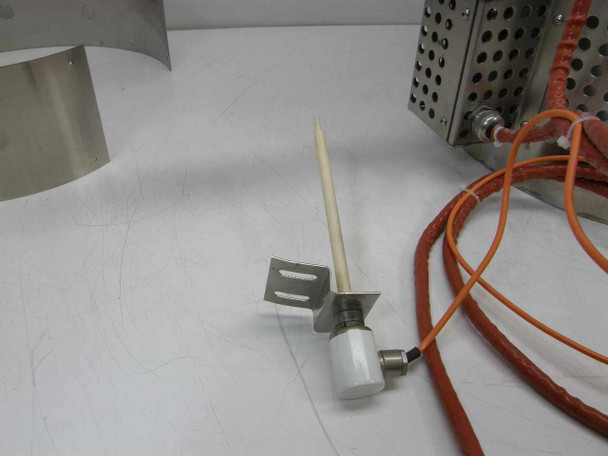 Thermocouple assembly removed and laid flat — ceramic-sheathed probe on stainless bracket with high-temperature silicone lead wires