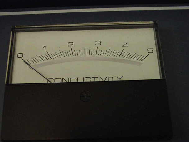 Close-up of analog conductivity panel meter face showing scale 0–5 labeled Conductivity