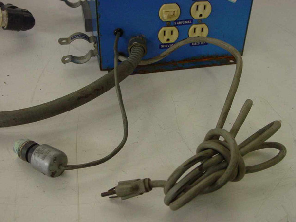 Rear view of Lakewood Instruments Model 200 showing three outlets, pipe clamp bracket hardware, power cord, and solenoid valve assembly with hose
