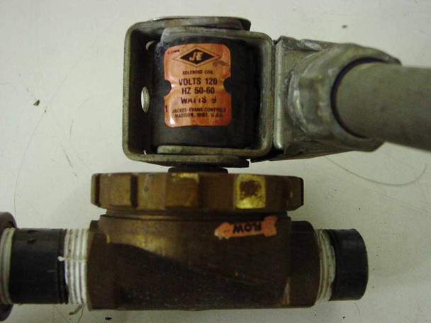 Close-up of Jack Evans solenoid valve coil showing label with Volts 120, Hz 50-60, Watts 9, Jack Evans Controls Madison WI USA, attached to brass valve body with Flow label