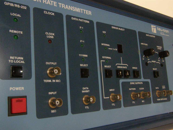 Tau-Tron STX-1101 front panel detail showing GPIB/RS-232 Local/Remote controls, Clock section with Clock Loss LED and BNC connectors, Data Pattern selector, Error Inject section, and Sync Outputs