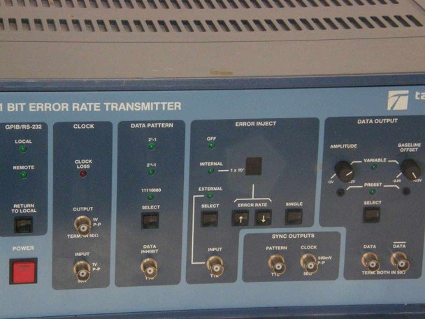 Tau-Tron STX-1101 front panel close-up showing Data Pattern (2^6-1, 2^9-1, 11110000), Error Inject (Internal/External, Error Rate, Single), Sync Outputs (Pattern, Clock TTL, Data 50 Ohm), and Data Output (Amplitude, Baseline Offset, Preset/Variable) controls