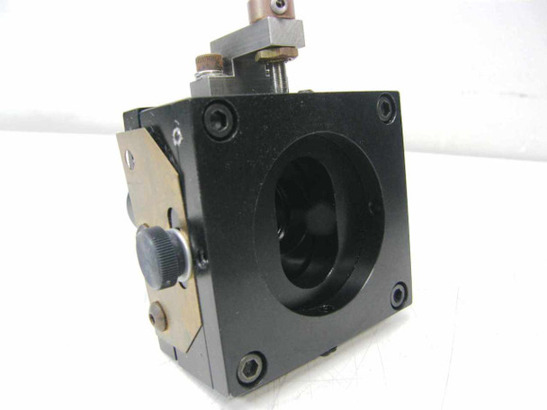 Rear view of linear stage optical mount showing circular bore, mounting screws, brass hardware, and fine-thread adjustment knob