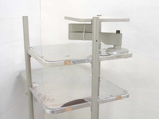 Anthro rolling computer cart close-up of upper shelves and adjustable monitor arm bracket with scuff wear visible on shelf surfaces