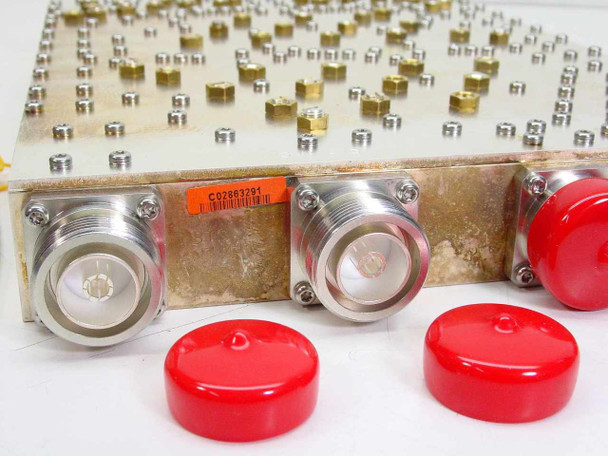 Close-up of RF duplexer connector face showing two large 7/16 DIN-style coaxial ports with red protective caps removed, orange asset tag visible, machined housing detail