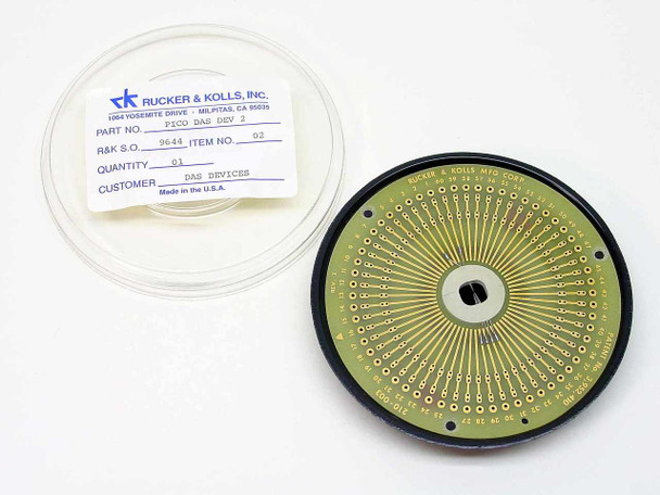 Rucker & Kolls 9644 PICO DAS DEV 2 circular IC test socket removed from clamshell case showing gold-plated radial contact pins on PCB — label visible beside unit