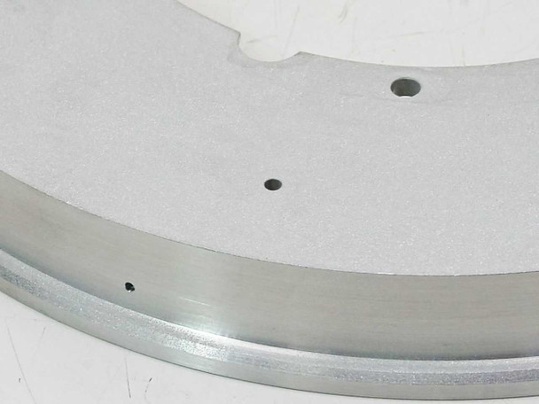 Close-up of stainless steel vacuum flange ring outer edge and flat machined surface with mounting hole detail