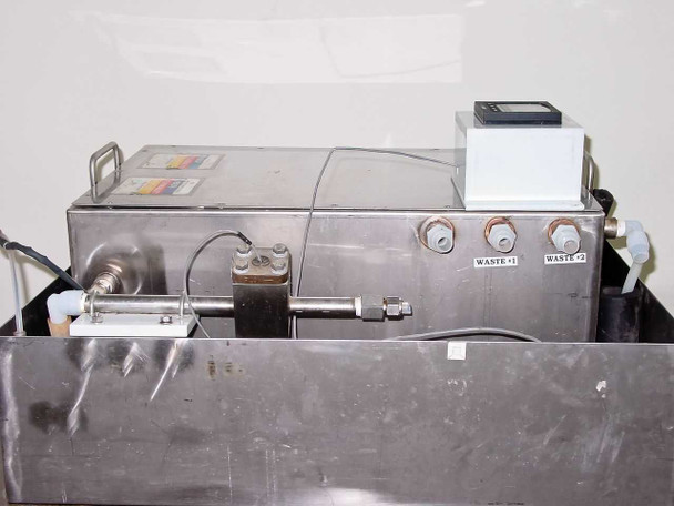 Close-up of PSR wash tank showing Waste 1 and Waste 2 outlet ports, flow sensor piping, and GF+ Signet 3-5100 digital meter unit