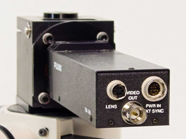 Rear panel of Pulnix TM-745 camera showing LENS BNC connector, VIDEO OUT multi-pin circular connector, and PWR IN / XT SYNC connector with labels
