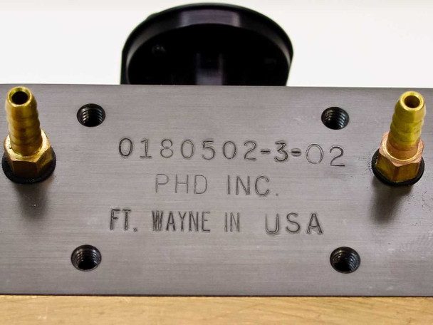 PHD Inc 0180502-3-02 label — engraved part number, PHD Inc manufacturer name, and Ft. Wayne IN USA origin stamped on top plate with two barbed brass fittings