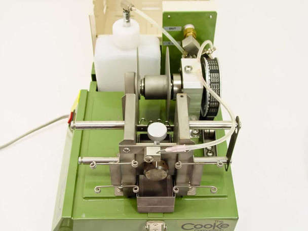 Front-facing view of TP-125 MK III fiber optic cleaner showing fiber chuck, guide rails, and abrasive/polishing wheel mechanism