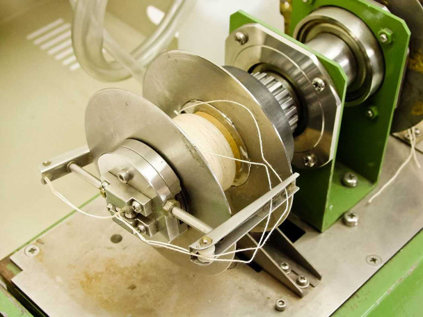 Close-up of TP-125mk2 peristaltic pump head with spool, guide wires, and stainless steel rollers