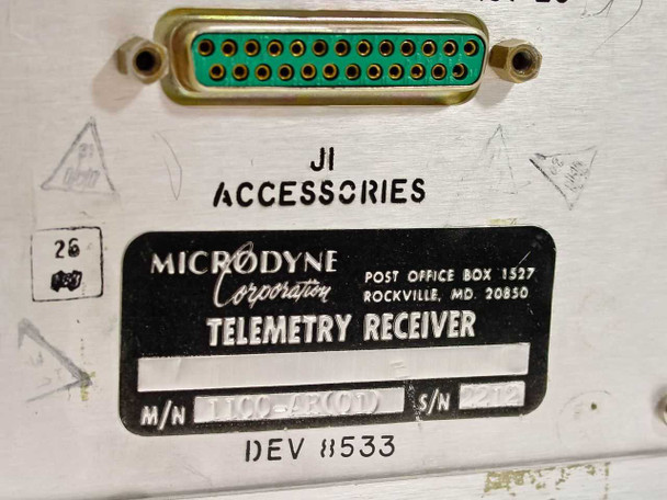 Close-up of Microdyne Corporation Telemetry Receiver rear identification label showing model 1100-AR(01), serial number, and JI Accessories D-sub 25-pin connector