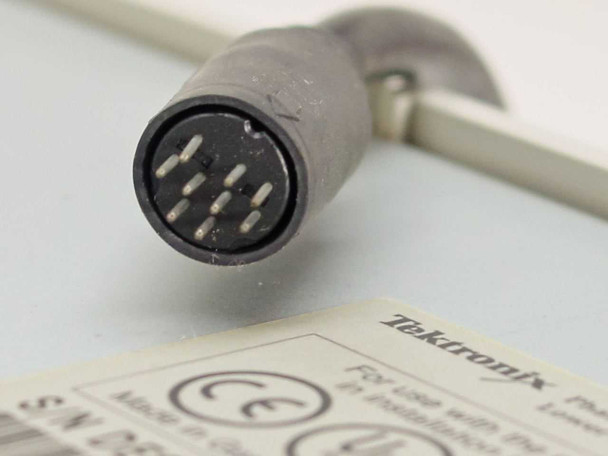 Close-up of multi-pin DIN-style connector on the interface cable attached to the Tektronix Phaser paper tray