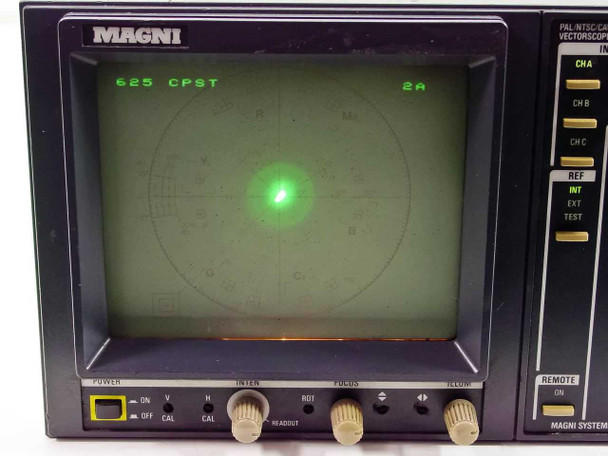 Magni VS561 Vectorscope front panel powered-on view showing CRT displaying '625 CPST 2A' graticule with green dot trace, front panel controls including POWER ON/OFF, INTEN, ROT, FOCUS, ILLUM knobs, and right-side input/format selector switches