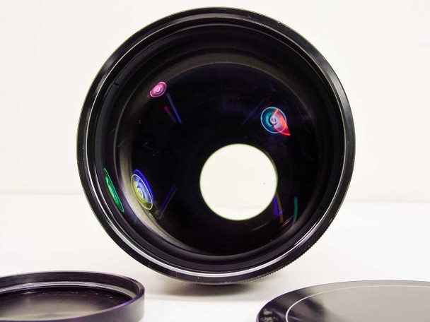 GE GL-132 projector lens rear optical element view showing multi-coated glass with colorful light reflections, both caps visible below