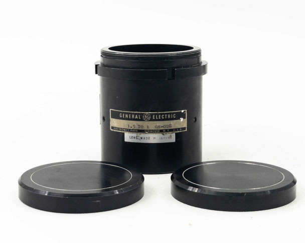 General Electric GS-028 projector lens in black cylindrical housing standing upright next to both lens caps, label showing 1.5 to 1 throw ratio and model GS-028