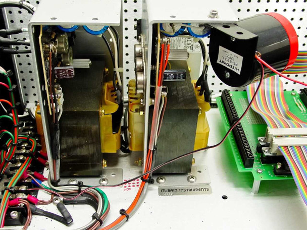 Interior detail showing two Astec power supply modules labeled 12V and 5V, McBain Instruments labeling, and ribbon cable connections