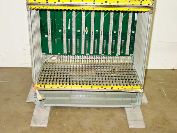 Rolm 9200 PBX chassis – lower shelf bay close-up showing empty card slots, backplane wiring harness connections, and floor stand