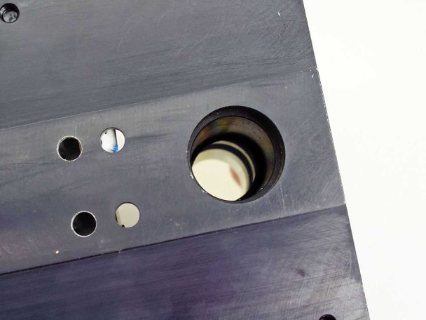 Close-up of circular optical aperture in shutter housing showing shutter blade disc and annular seal ring detail