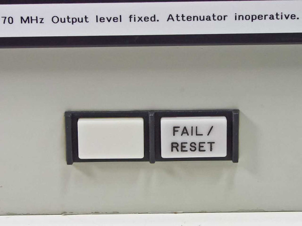 Close-up of front panel CRT display reading '70 MHz Output level fixed. Attenuator inoperative.' with FAIL/RESET button below