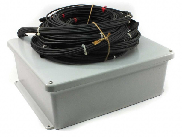 First Solar fused combiner box closed — gray outdoor-rated plastic enclosure with bundled 10-string MC3 wiring harness coiled on top, front-left view