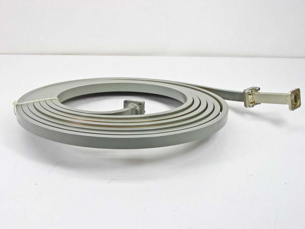Micro-Coax 1010 WR-62 flexible waveguide delay line coiled side profile view showing flat rectangular cross-section and one flanged termination