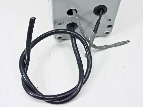 Close-up of Hoffman E-2PB833NM wiring leads — black and gray cables exiting the enclosure base with visible wire labels