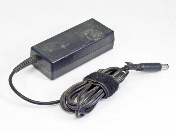 HP 463552-004 AC adapter — angled view showing dust and surface scuffing on top of the black plastic housing