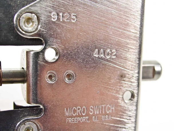 Micro Switch 9125 close-up of stamped markings on mounting plate — model 9125, variant 4AC2, and MICRO SWITCH Freeport IL USA manufacturer stamp