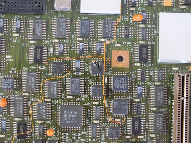 Close-up of IBM 85F0434 motherboard showing cracked chip area with orange marking circles highlighting damage