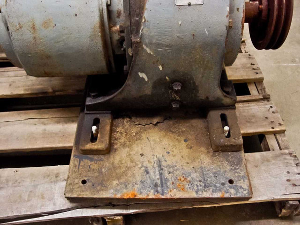 Steel base plate mounting feet on GE variable speed motor assembly — shows surface corrosion and rust on mounting hardware