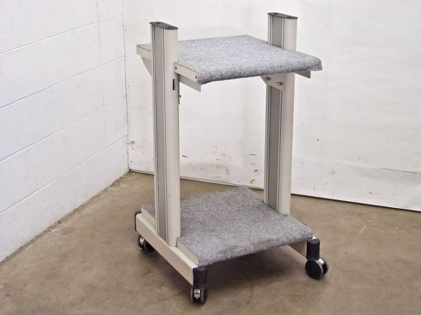 Unbranded white two-tier rolling cart with carpeted shelves — front-left three-quarter view showing both shelf levels and casters