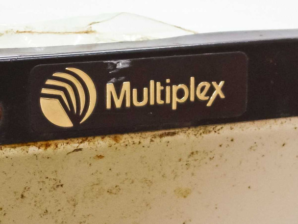 Close-up of Multiplex logo on black trim — rust and corrosion visible on cream-colored metal housing below logo and cracked Plexiglas visible at top