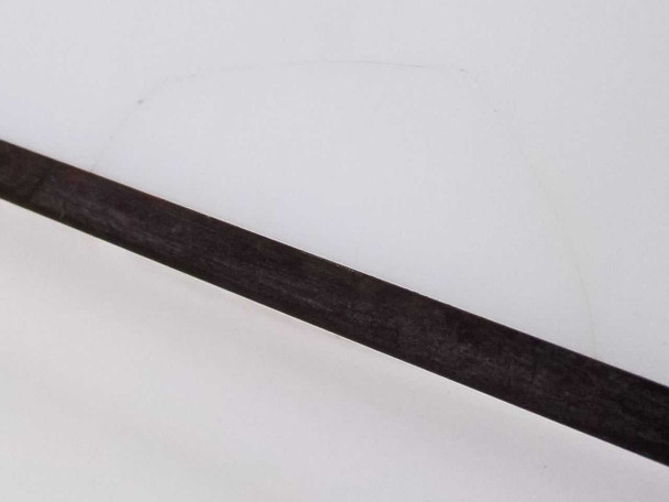 Close-up of black metal support strut showing surface wear and scratching